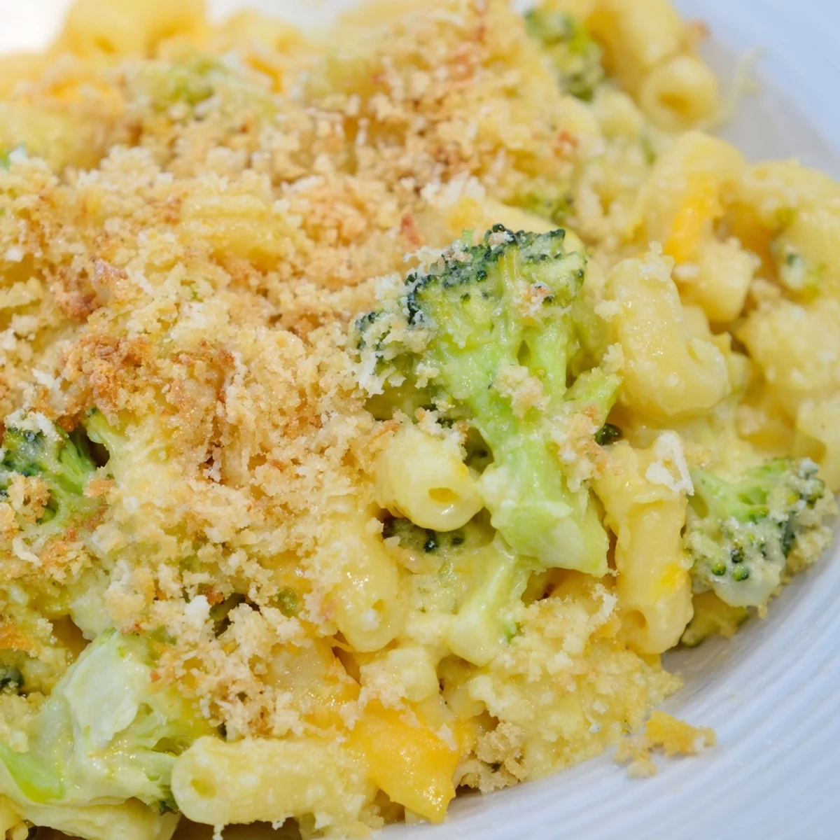Golden Baked Macaroni and Cheese with Broccoli Florets topped with crunchy panko crumbs emerges from the oven, bubbling and beautifully browned.
