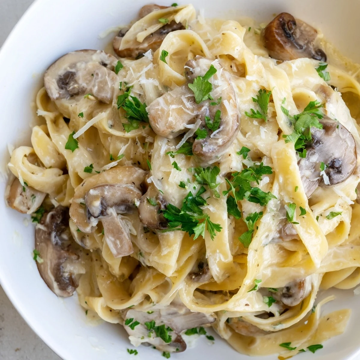 Creamy Fettuccine Alfredo with Mushrooms served hot with chopped parsley garnish and rich Parmesan sauce