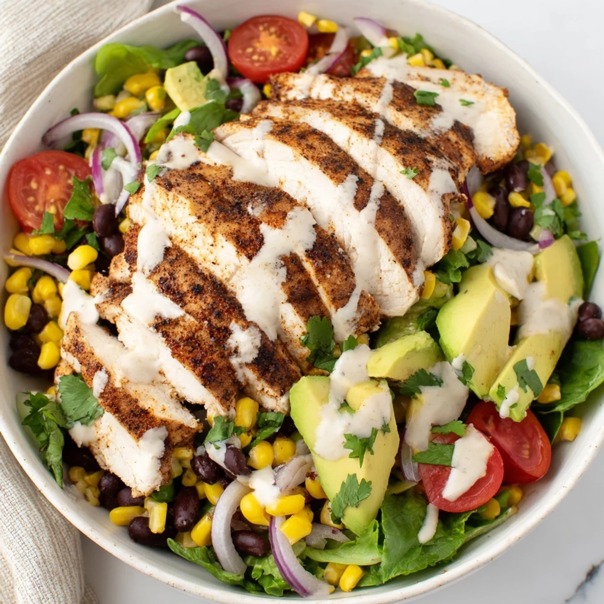 Sliced grilled chicken rests on a bed of crisp greens, bright cherry tomatoes, and creamy avocado in the Southwest Chicken Salad.