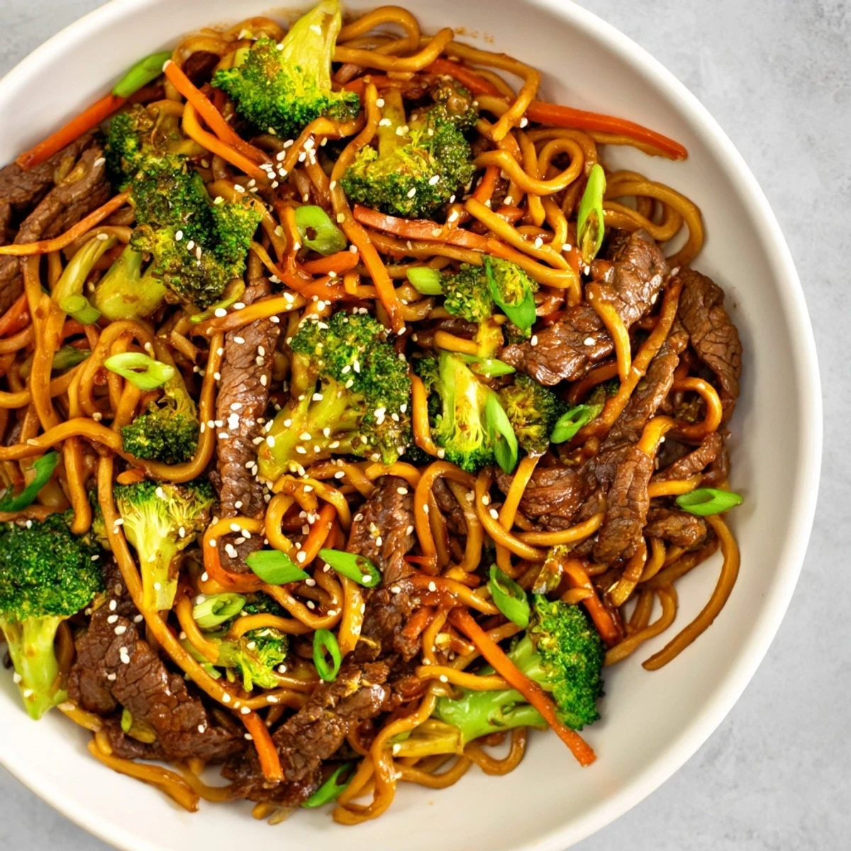 Overhead view of freshly tossed Beef and Broccoli Lo Mein with crunchy sesame seeds, ready to serve for dinner.
