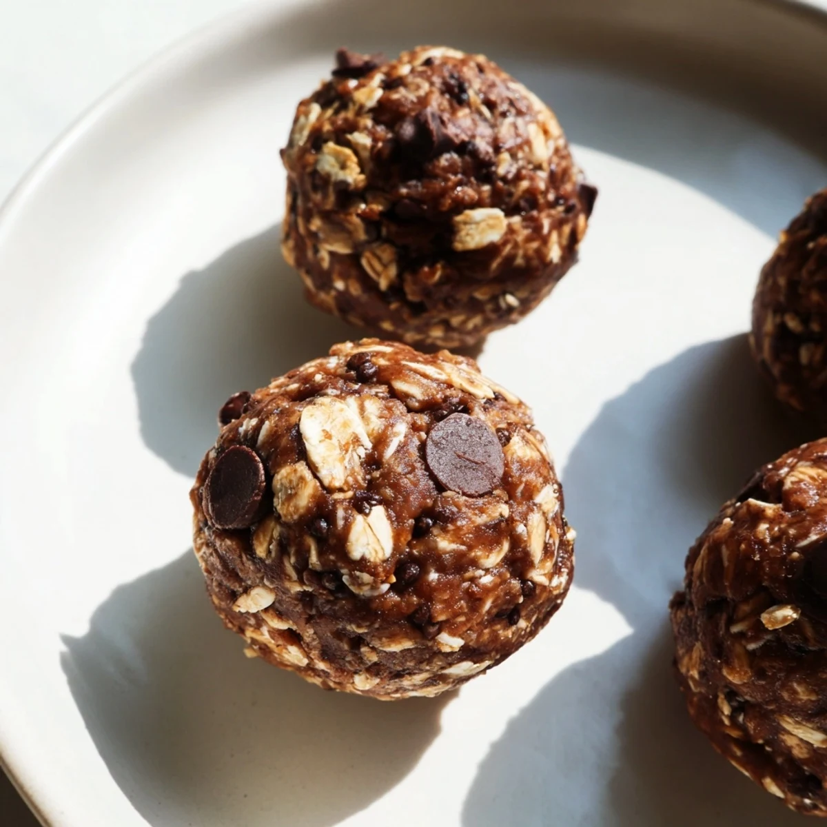 A close-up of Chocolate Peanut Butter Energy Bites shows a chewy, textured surface dotted with chia seeds and mini chocolate chips.  