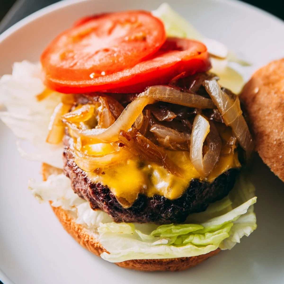 Golden-brown caramelized onions melt over a juicy Classic Beef Burger, served on a toasted bun with lettuce and tomato.
