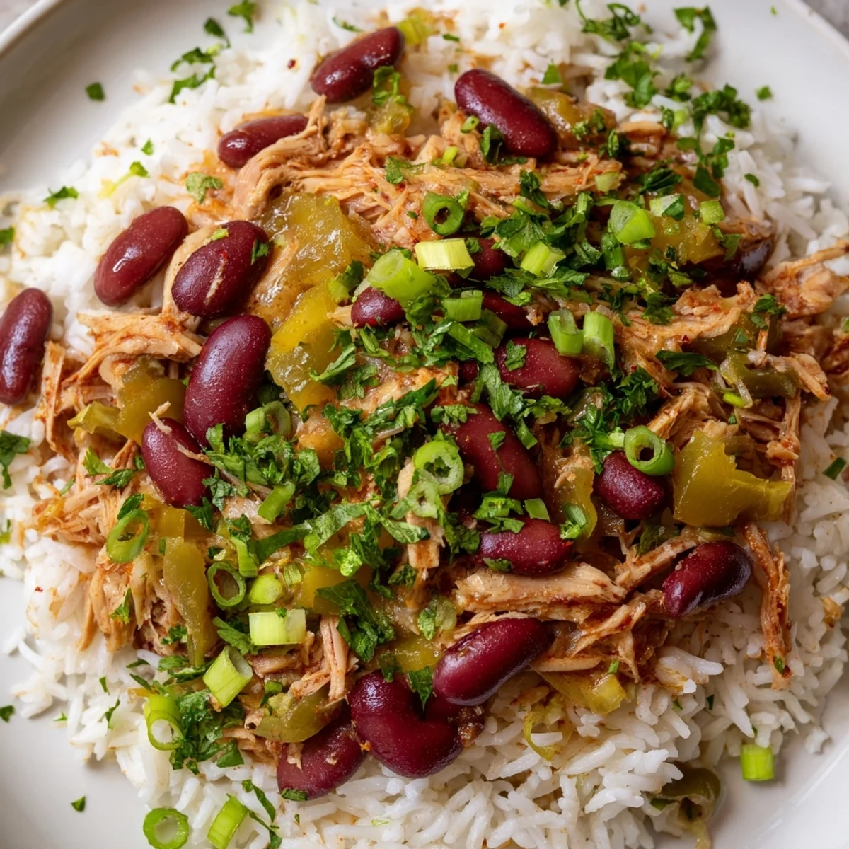 Homestyle Creole Red Beans and Rice with Smoked Turkey ladled over white rice, garnished with green onions.