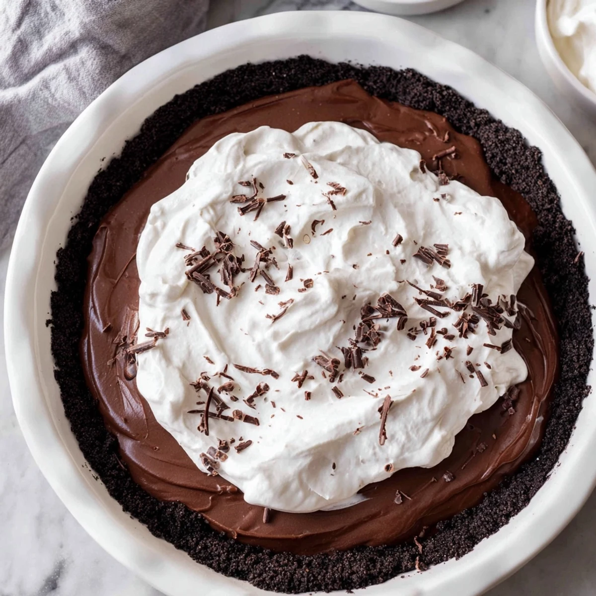 Freshly sliced Chocolate Silk Pie with Whipped Cream reveals its ultra-creamy, silky smooth texture, perfect for chocolate lovers.
