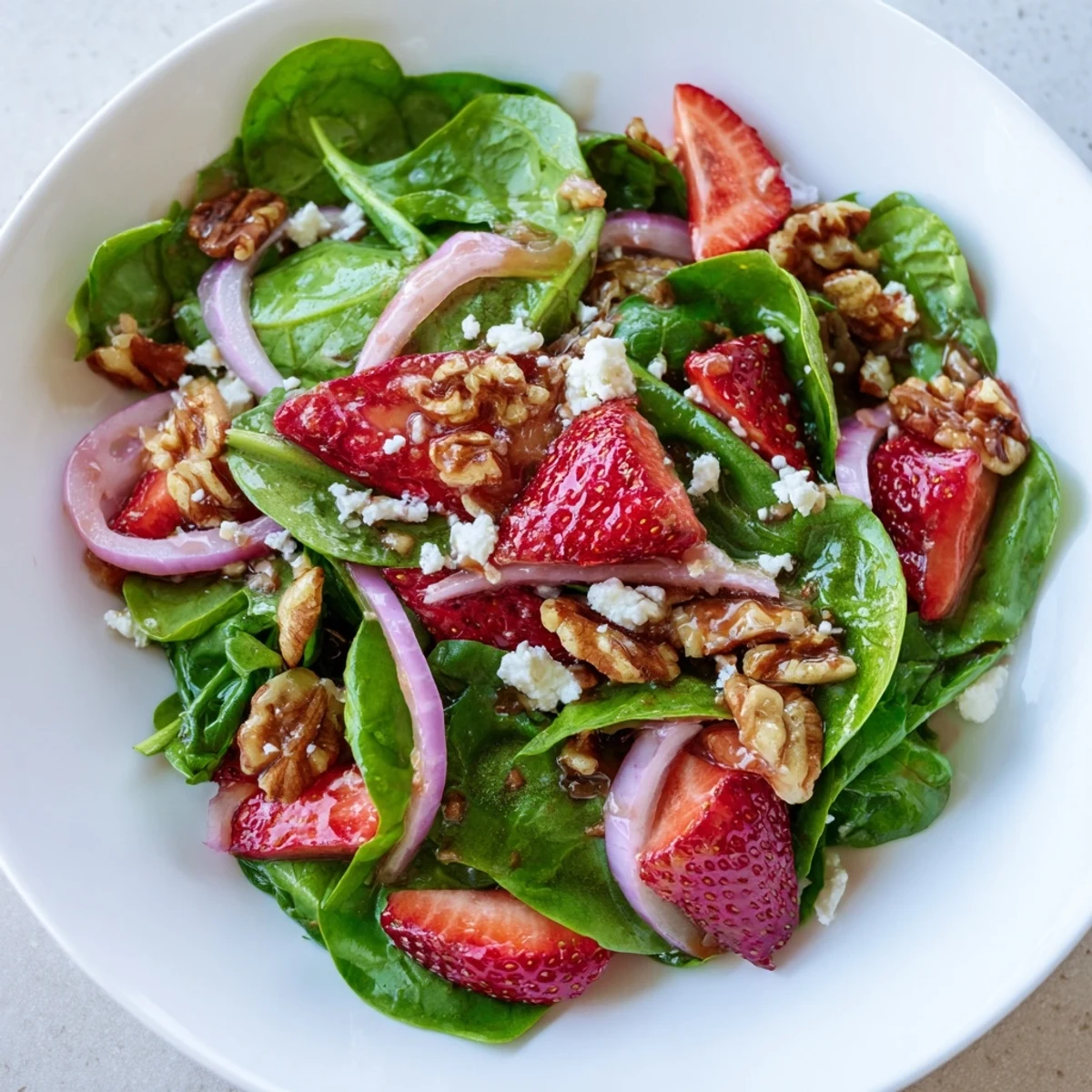 Fresh baby spinach leaves topped with sliced sweet strawberries and crunchy candied walnuts in this Strawberry Spinach Salad with Candied Walnuts.
