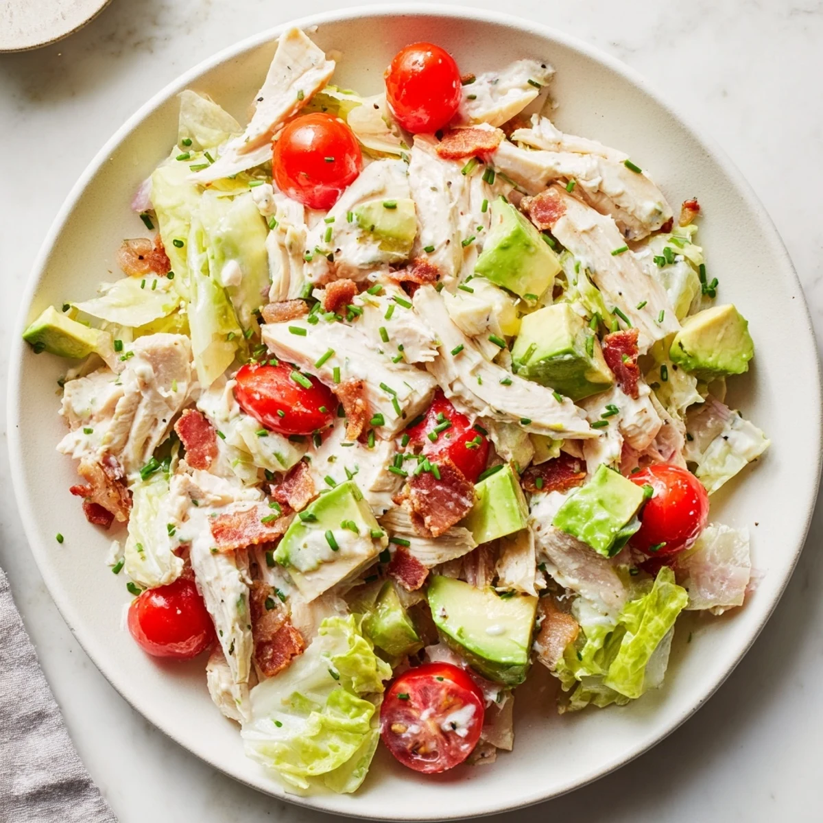 Close-up of chopped BLT Chicken Salad featuring tender chicken, bacon bits, and vibrant red tomatoes for a satisfying meal.
