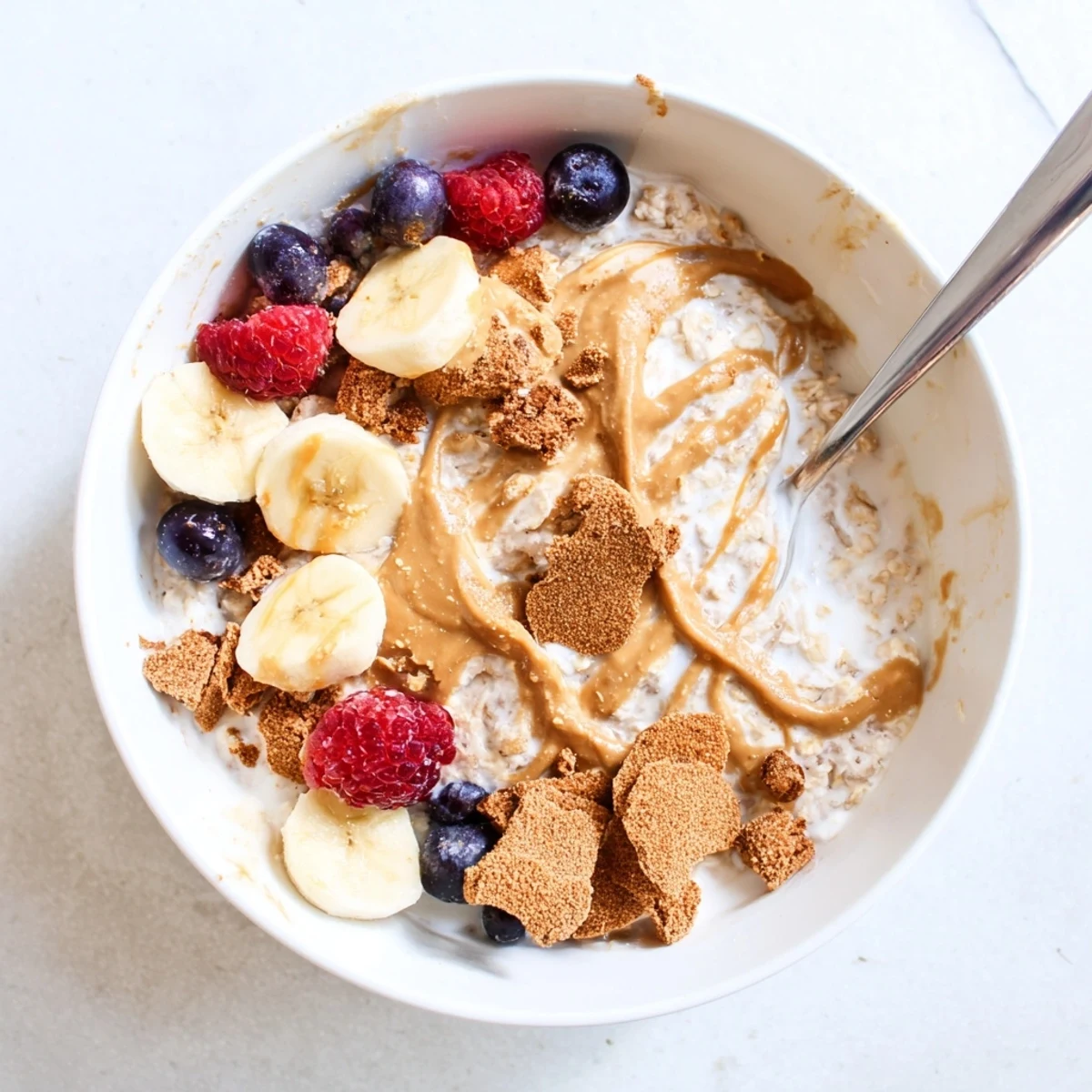 Overnight oats with Biscoff spread, creamy texture, and crunchy cookie crumbles ready to enjoy straight from the fridge.