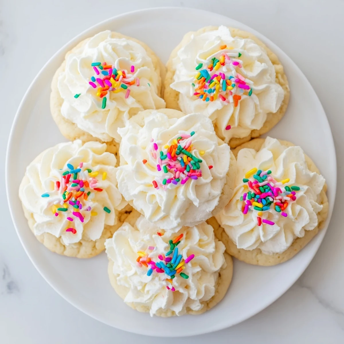Brightly frosted Walmart-Style Sugar Cookies with Buttercream Frosting stacked on a cooling rack for easy serving.