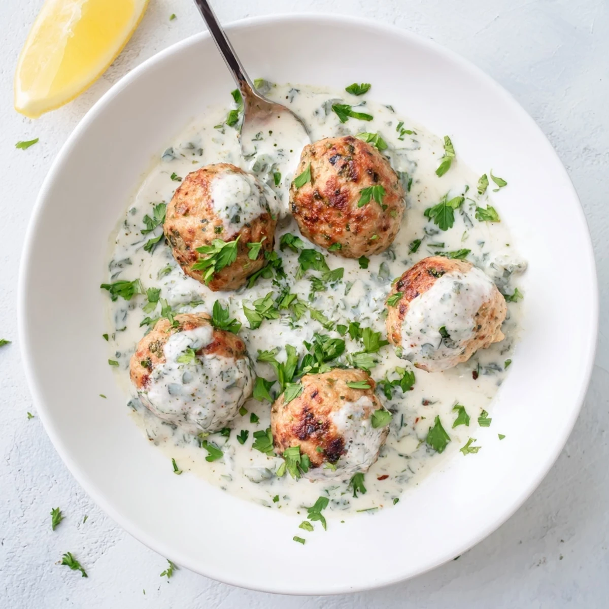 Hearty Chicken Kofta served with a tangy garlic yogurt sauce alongside pita and fresh vegetables.