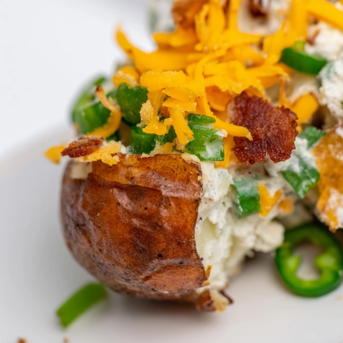 Creamy Jalapeno Popper Roasted Potato Salad garnished with fresh jalapeno slices and green onions.