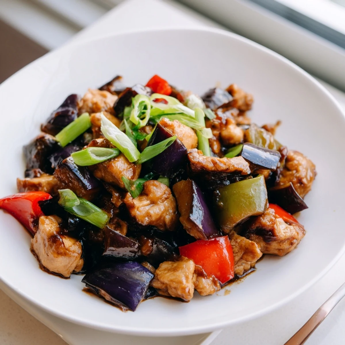 Black Vinegar Chicken With Bell Peppers And Eggplant in a hot wok with fluffy steamed rice.