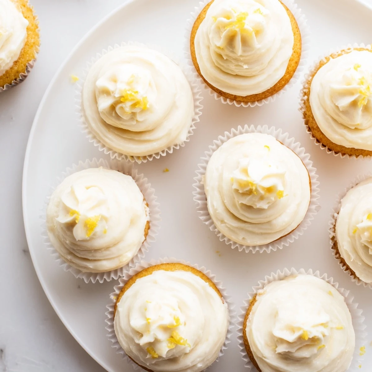 A close-up of Elderflower Cupcakes brushed with syrup, ready for an afternoon tea serving.