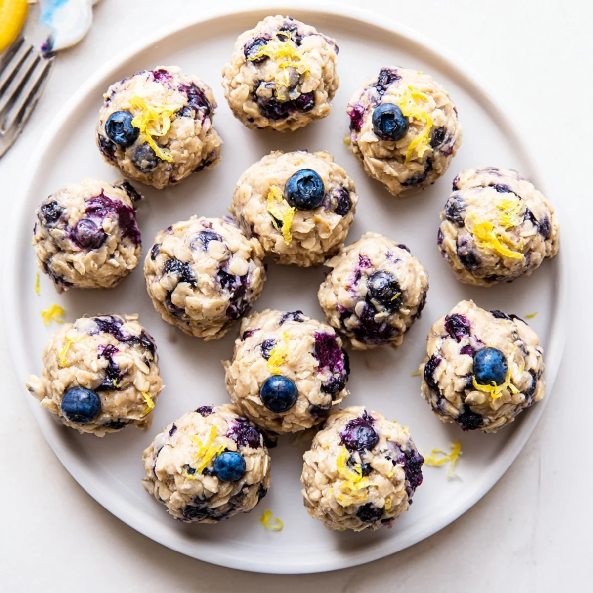 A close-up of one blueberry cheesecake protein bite showing creamy filling, chewy oats, and bursts of blueberry, perfect for a post-workout energy boost.
