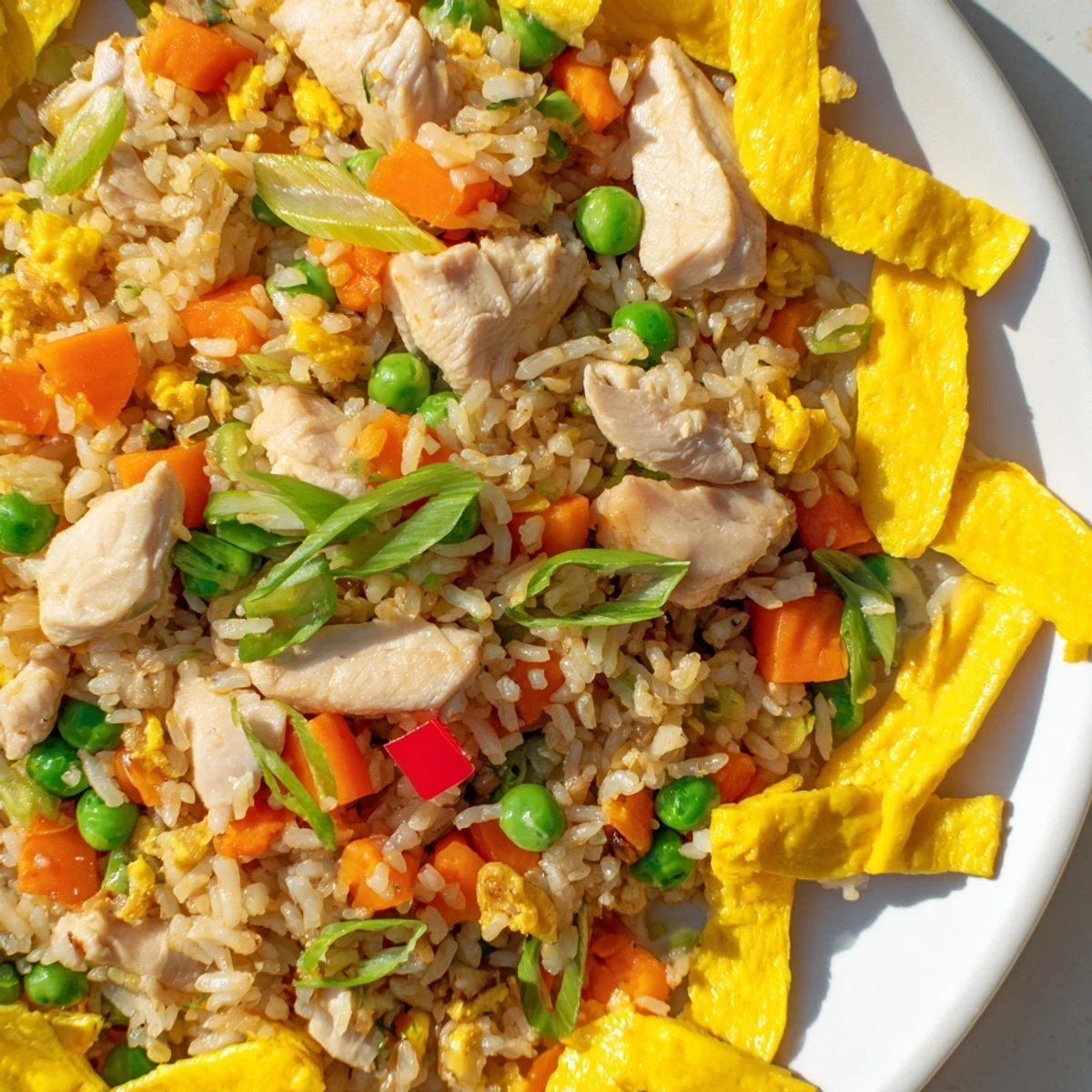 Savory Asian-style chicken fried rice stir-fried with tender meat and crisp veggies in a deep wok