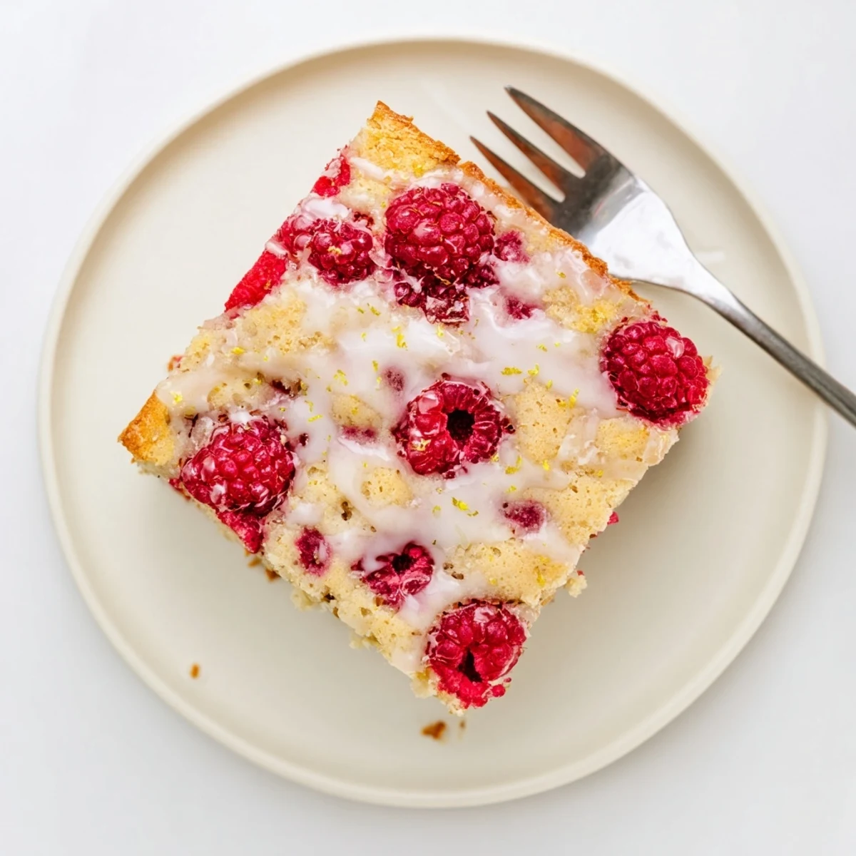 Soft baked Raspberry Lemon Blondies squares with powdered sugar glaze and berry garnish