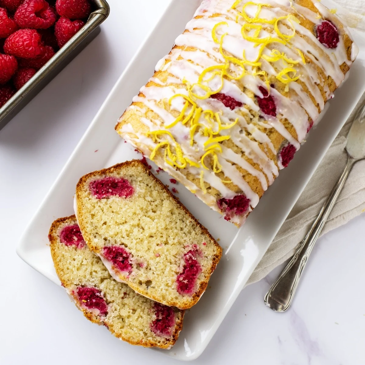 Rustic raspberry lemon poppyseed loaf cake served on a wooden board with fresh raspberries