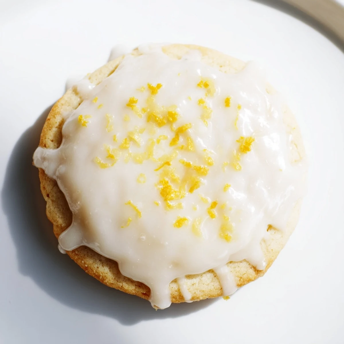 Close up of lemon frosted cookies with glossy icing and citrus garnish