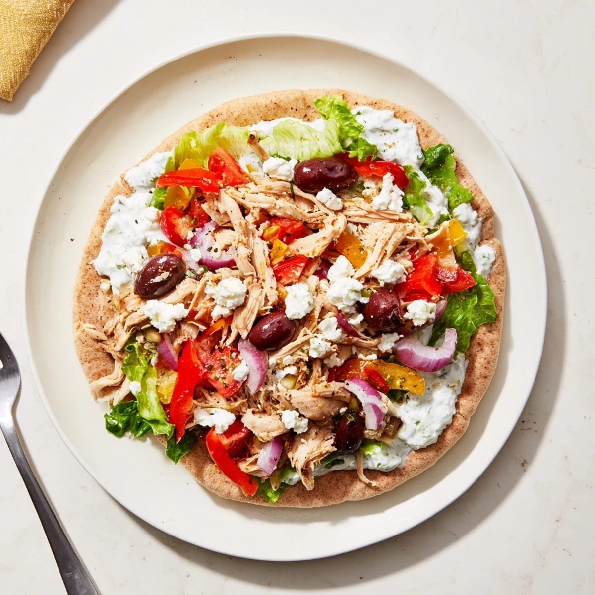 Mediterranean style Crockpot Greek chicken pitas drizzled with creamy tzatziki sauce and crumbled feta cheese
