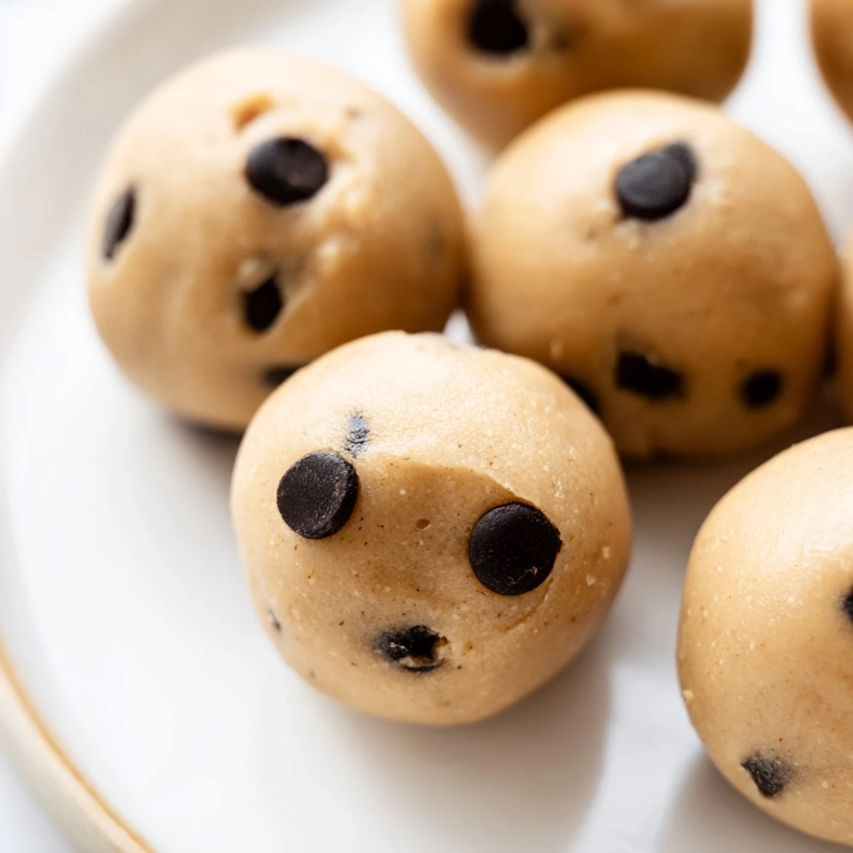 Bite-sized chocolate chip cookie dough protein balls rolled and ready for healthy snacking