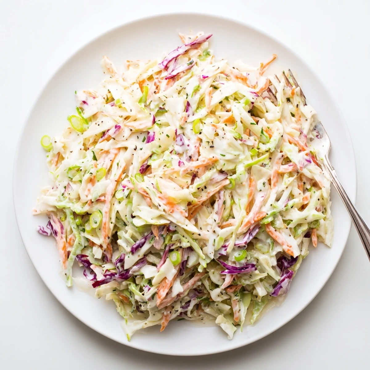 Colorful shredded vegetables coated in smooth mayonnaise dressing for this easy creamy coleslaw