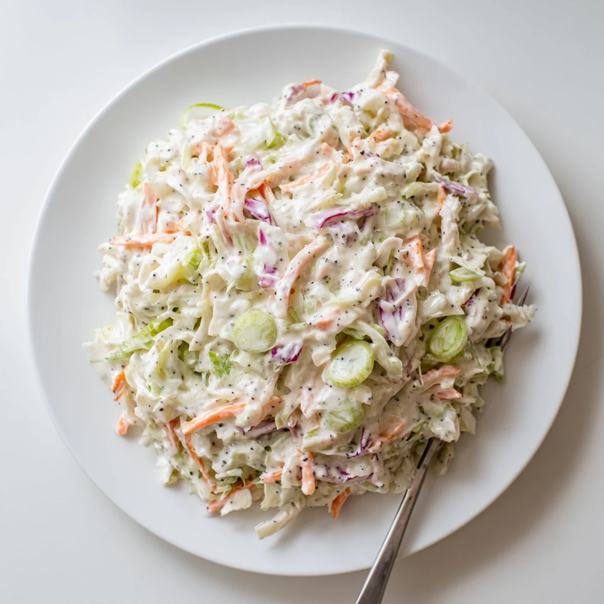 Fresh cabbage and carrot salad topped with tangy homemade dressing in easy creamy coleslaw