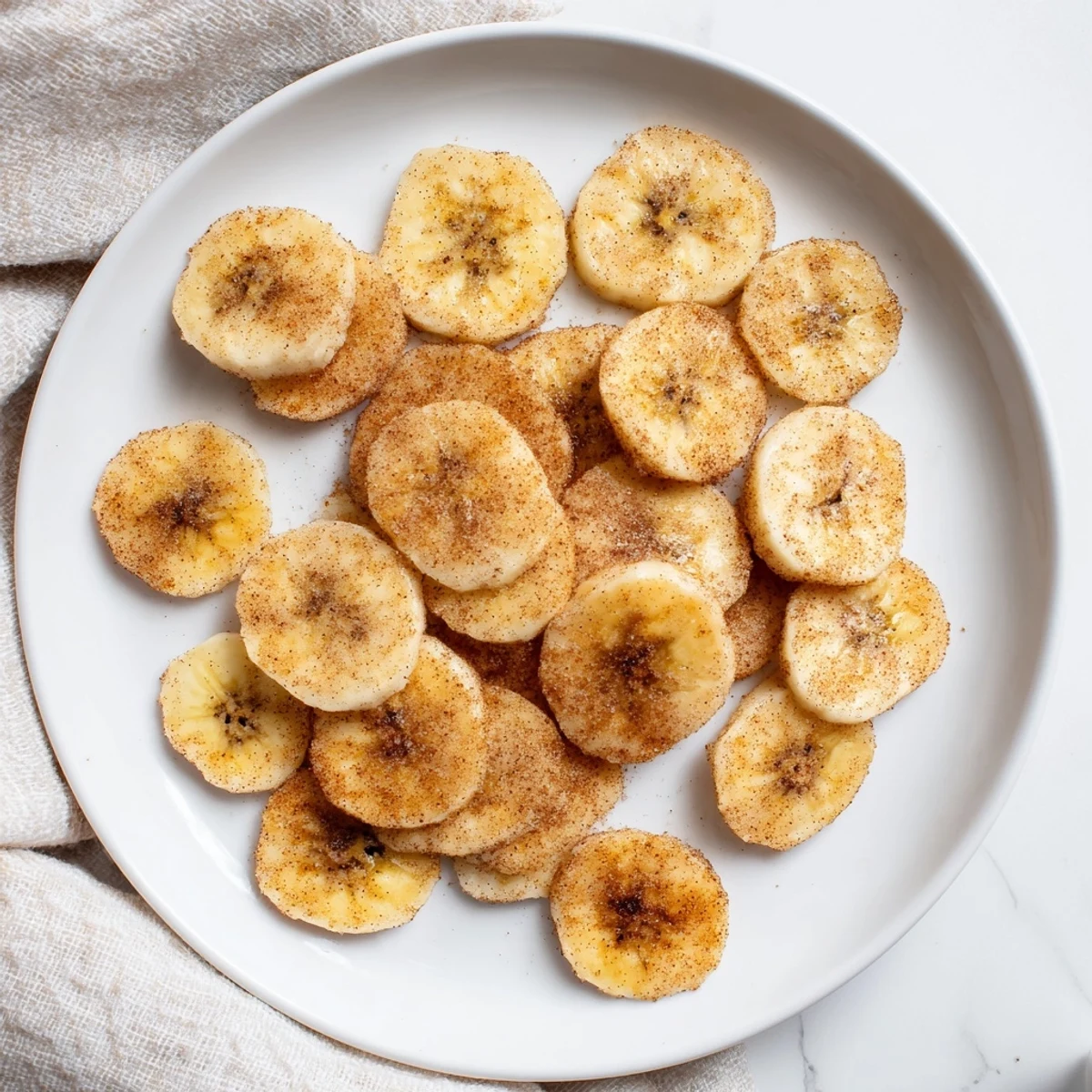 Stack of sweet cinnamon sugar coated banana chips showing their golden crispy texture and edges