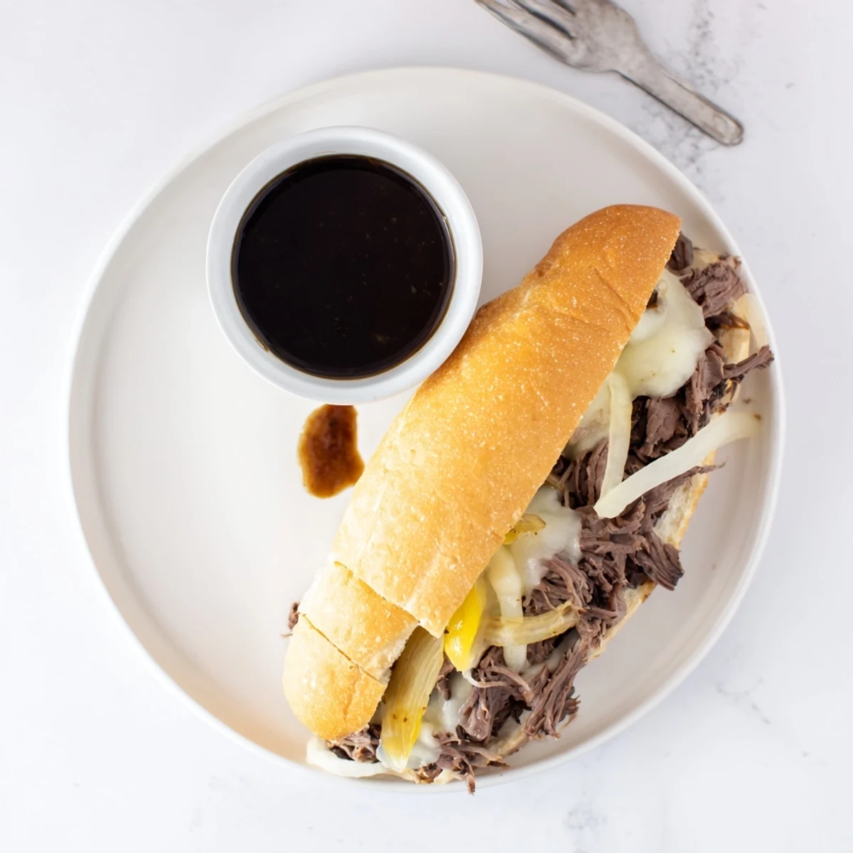 Tender shredded beef piles onto soft rolls for these classic slow cooker Crockpot French Dip Sandwiches with savory broth