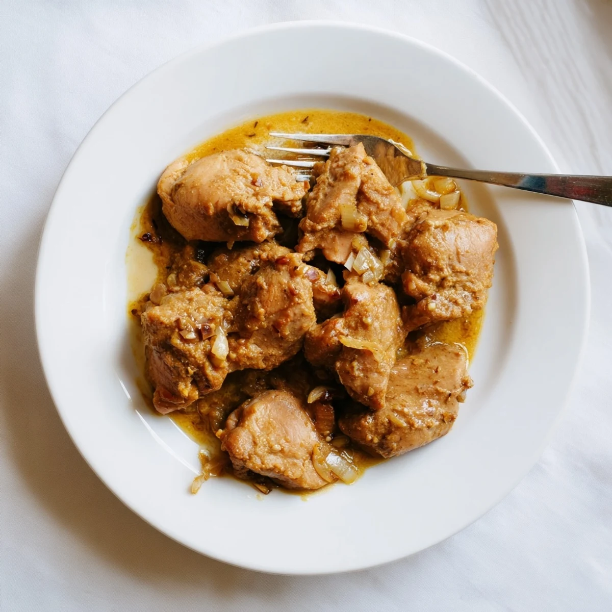 Tender slow-cooked chicken thighs smothered in a thick white gravy with herbs