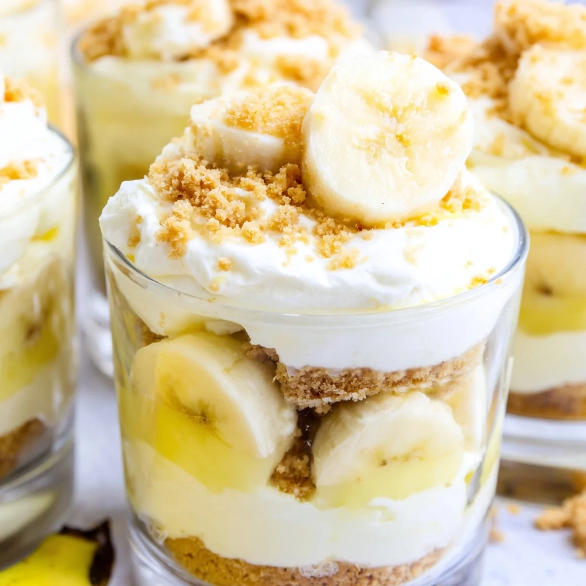 Creamy banana pudding cheesecake cups layered with vanilla wafer crumbs and fresh banana slices