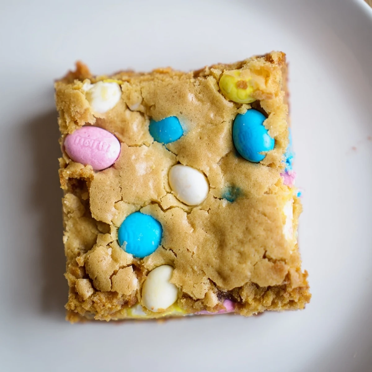 Chewy Mini Cadbury Easter Egg Blondies with colorful candy pieces scattered across golden, rich squares