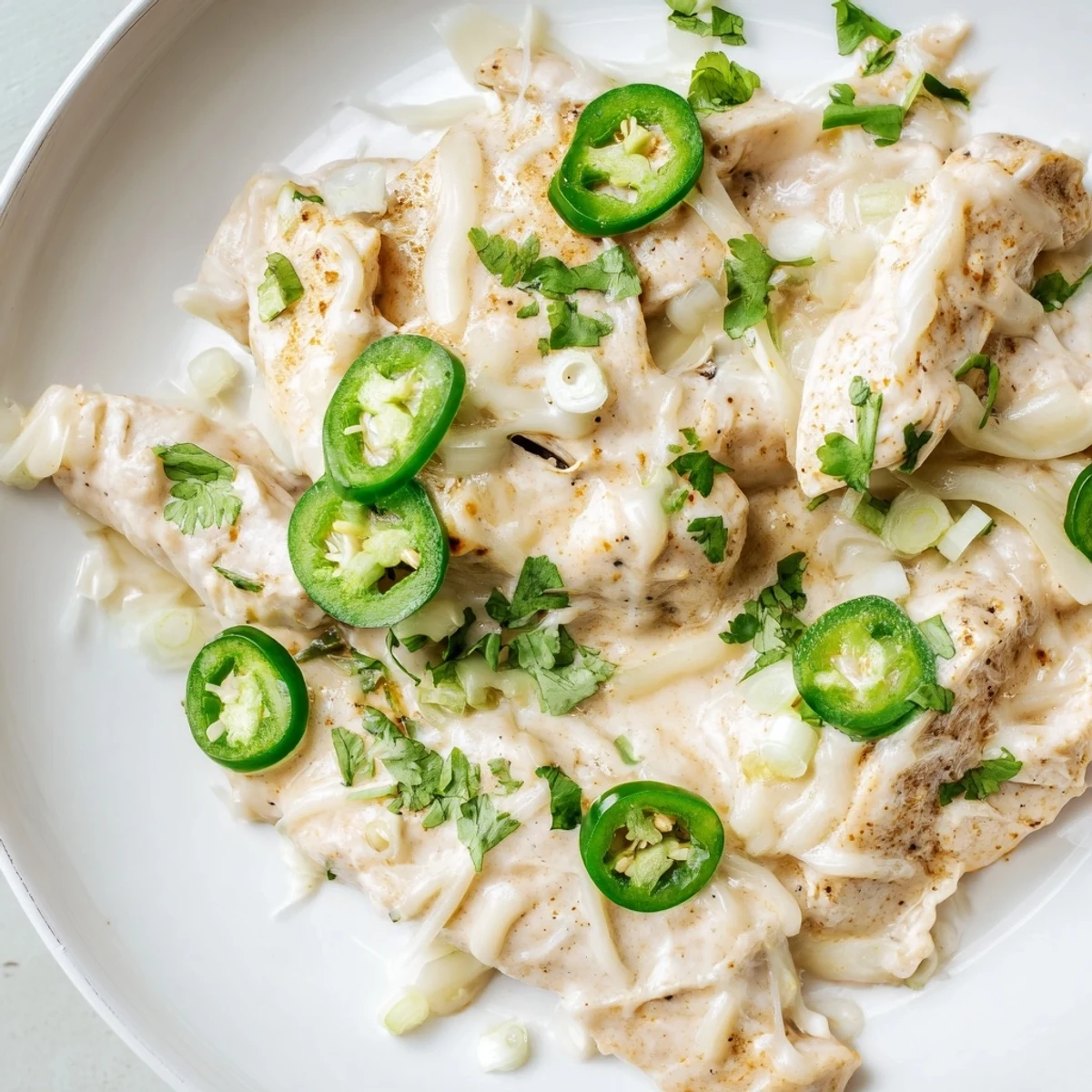 Golden jalapeno chicken breasts smothered in creamy melted cheese sauce with fresh cilantro