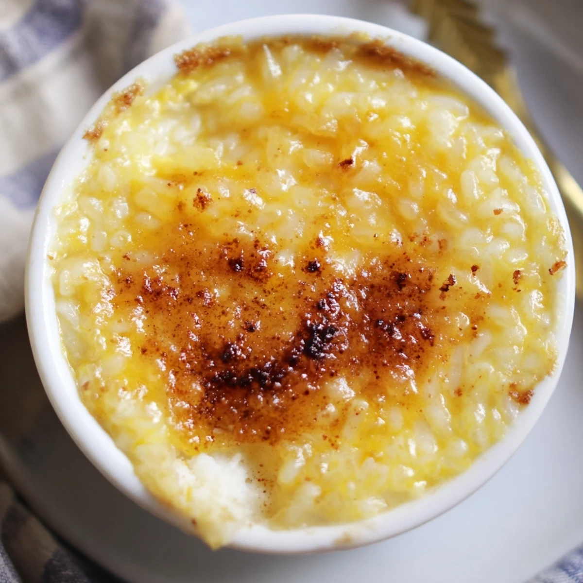 Silky Portuguese rice custard with a caramelized cinnamon dusting in white serving dishes