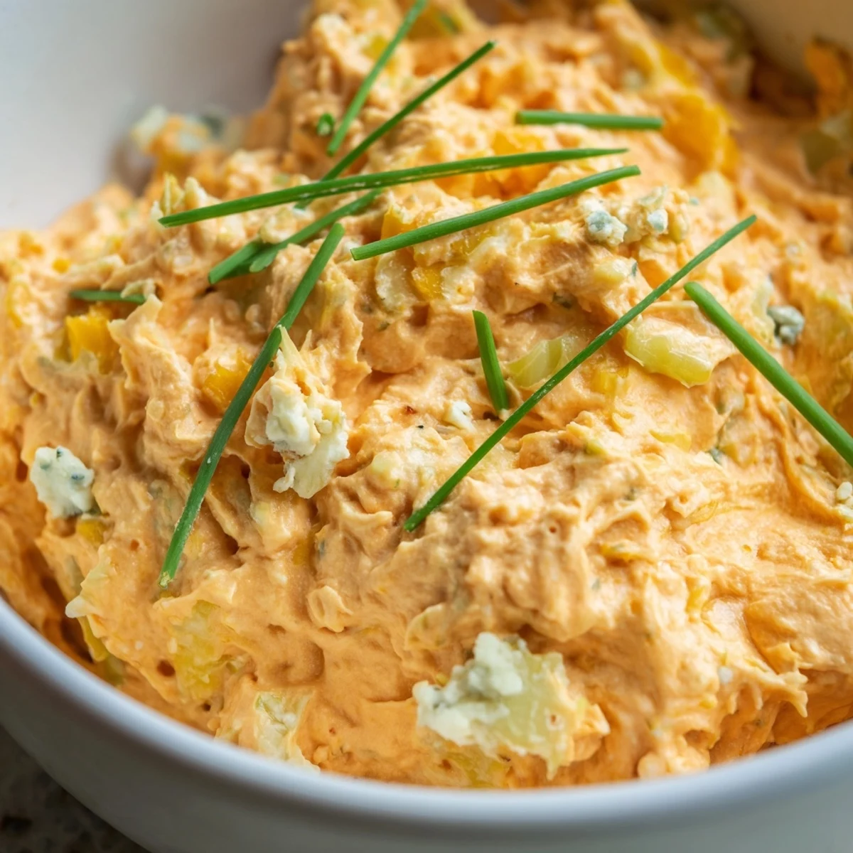 Tangy buffalo pickle dip served with crispy chips and crunchy celery sticks for dipping