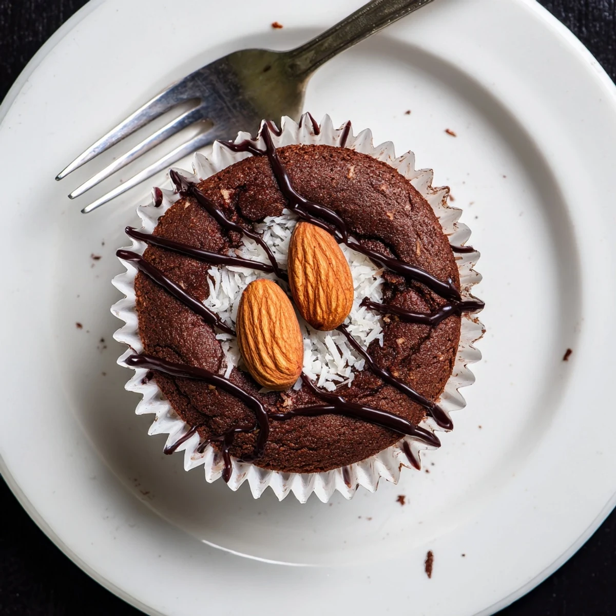 Rich Flourless Almond Joy Cupcakes with gooey coconut centers dusted in dark cocoa powder close-up