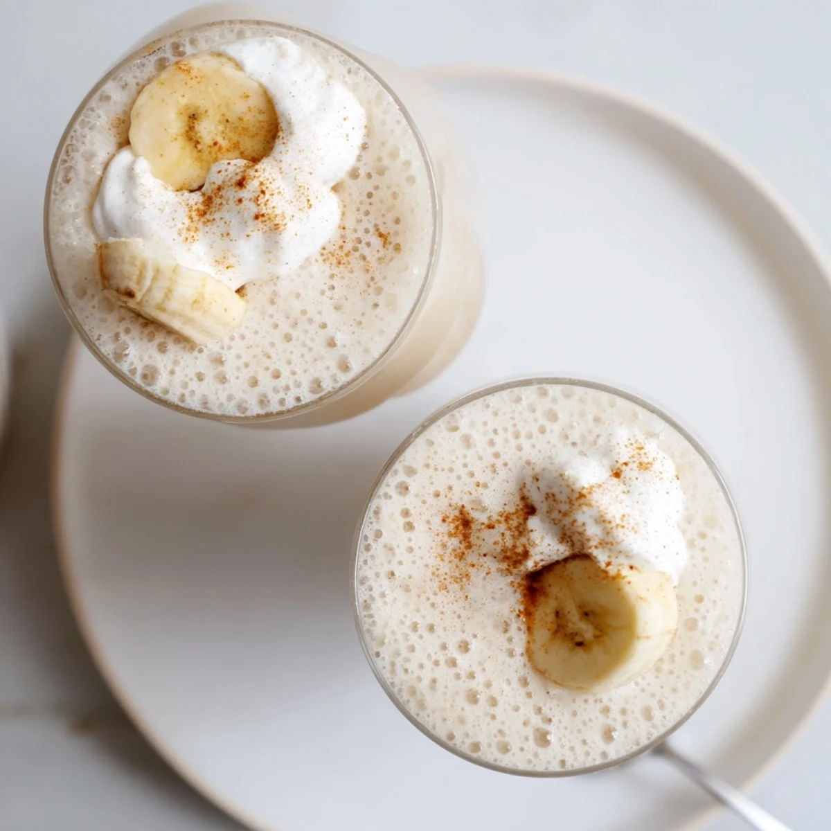 Creamy Vanilla Banana Shake in chilled glasses, frothy texture and banana slices