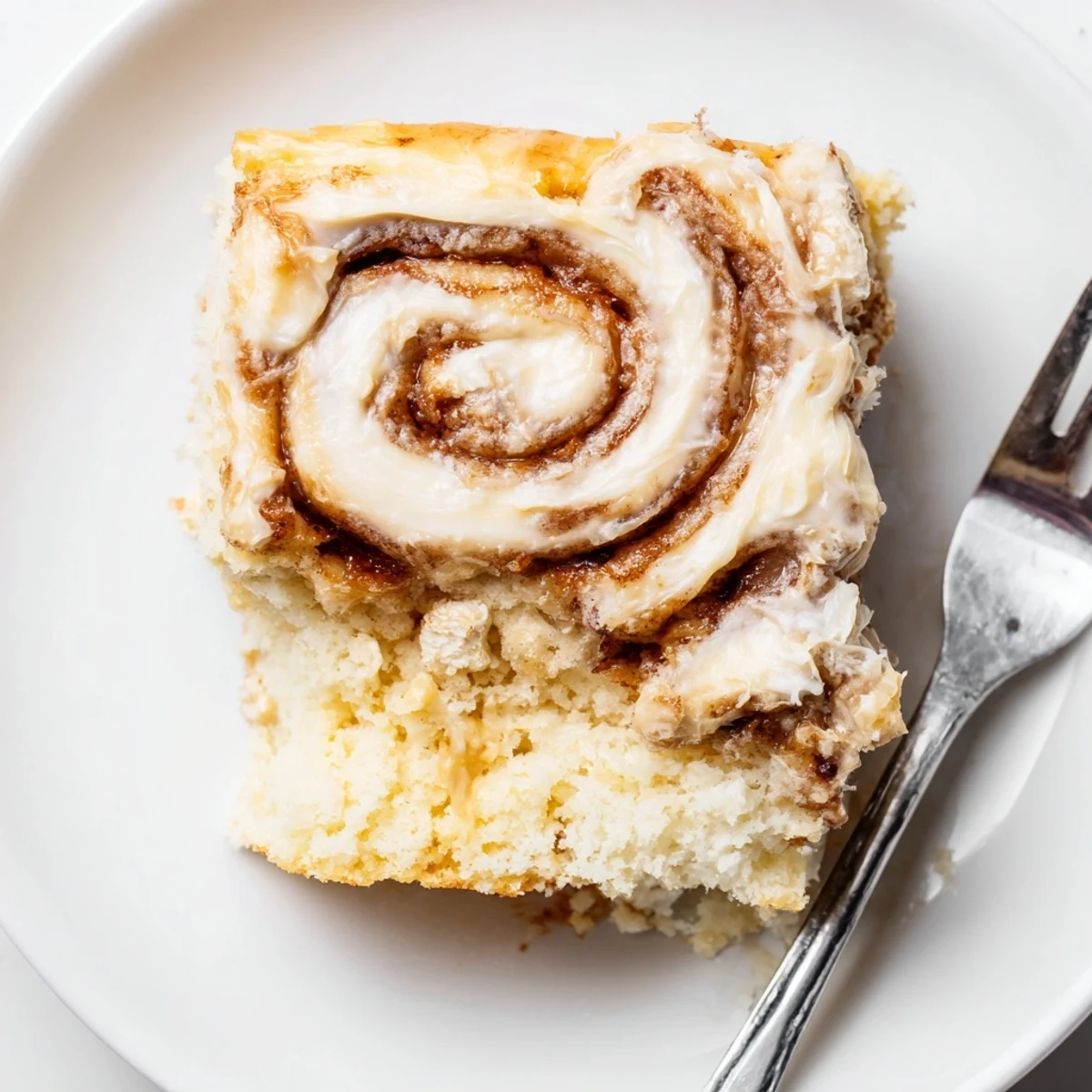 Fresh-baked Cinnamon Roll Poke Cake on tray, sticky swirls and tender crumbs.