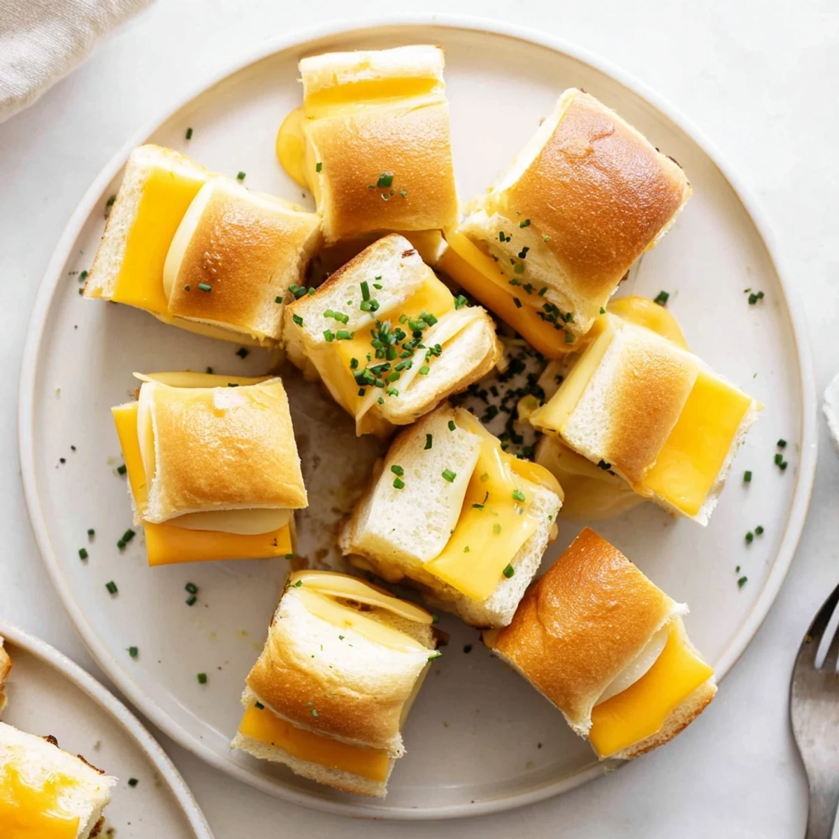 Pull-apart Mini Grilled Cheese Hawaiian Rolls served with warm tomato soup, sprinkled chives