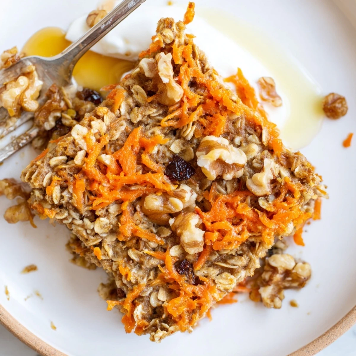 Slices of Carrot Cake Baked Oatmeal topped with creamy yogurt and walnuts
