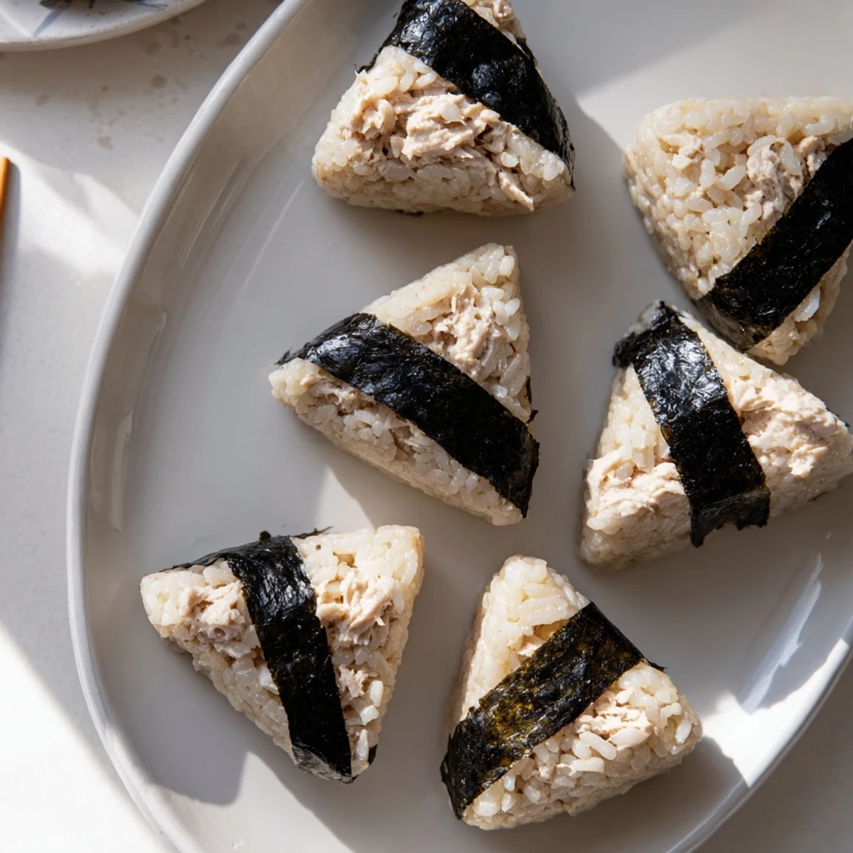 Freshly shaped tuna mayo onigiri with savory seaweed wrapper ready for snacking