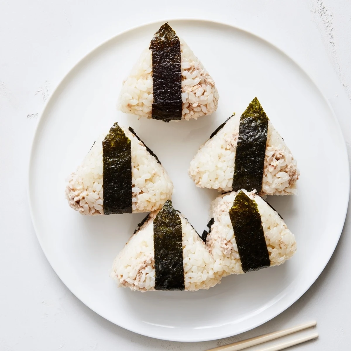 Handheld Japanese rice ball stuffed with creamy tuna mayonnaise filling for lunchbox