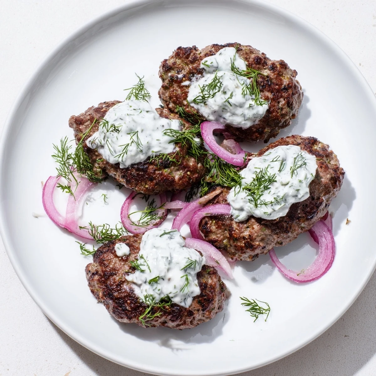 Juicy spiced beef patties paired with creamy yogurt dipping sauce and red onion slices