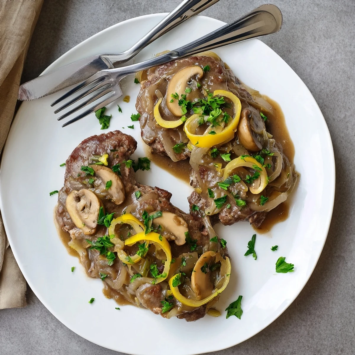 Golden brown cube steaks smothered in rich onion mushroom gravy served over creamy mashed potatoes