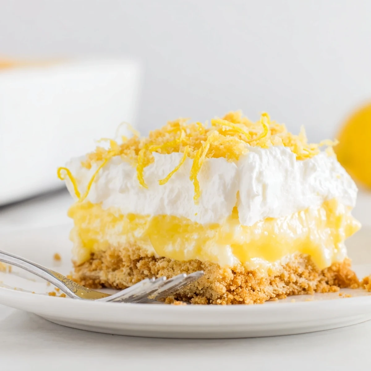 Lemon Lush Cake with glossy whipped topping and bright lemon zest, chilled