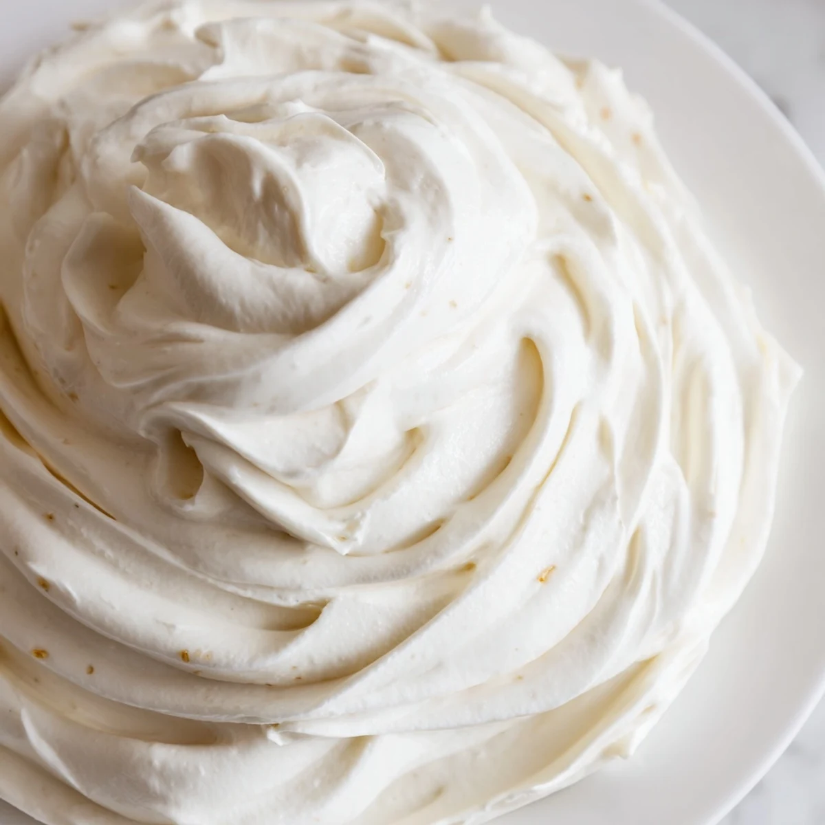 Creamy Italian meringue buttercream piled high on a freshly frosted layer cake