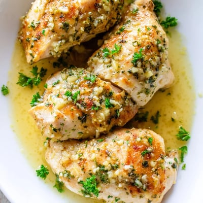 Juicy garlic butter baked chicken breast sliced open revealing tender meat with fresh parsley